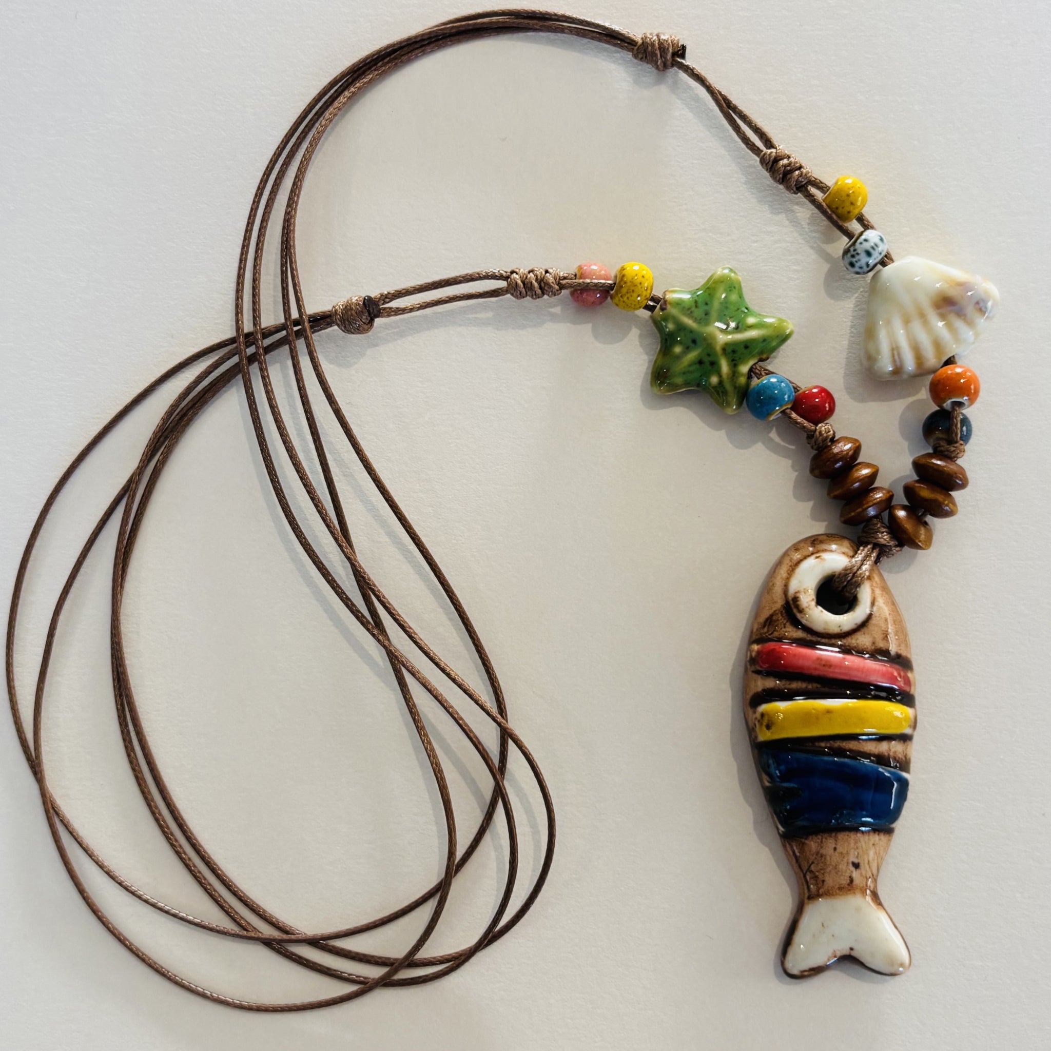 Colorful fish-shaped pendant on a cord necklace with beads