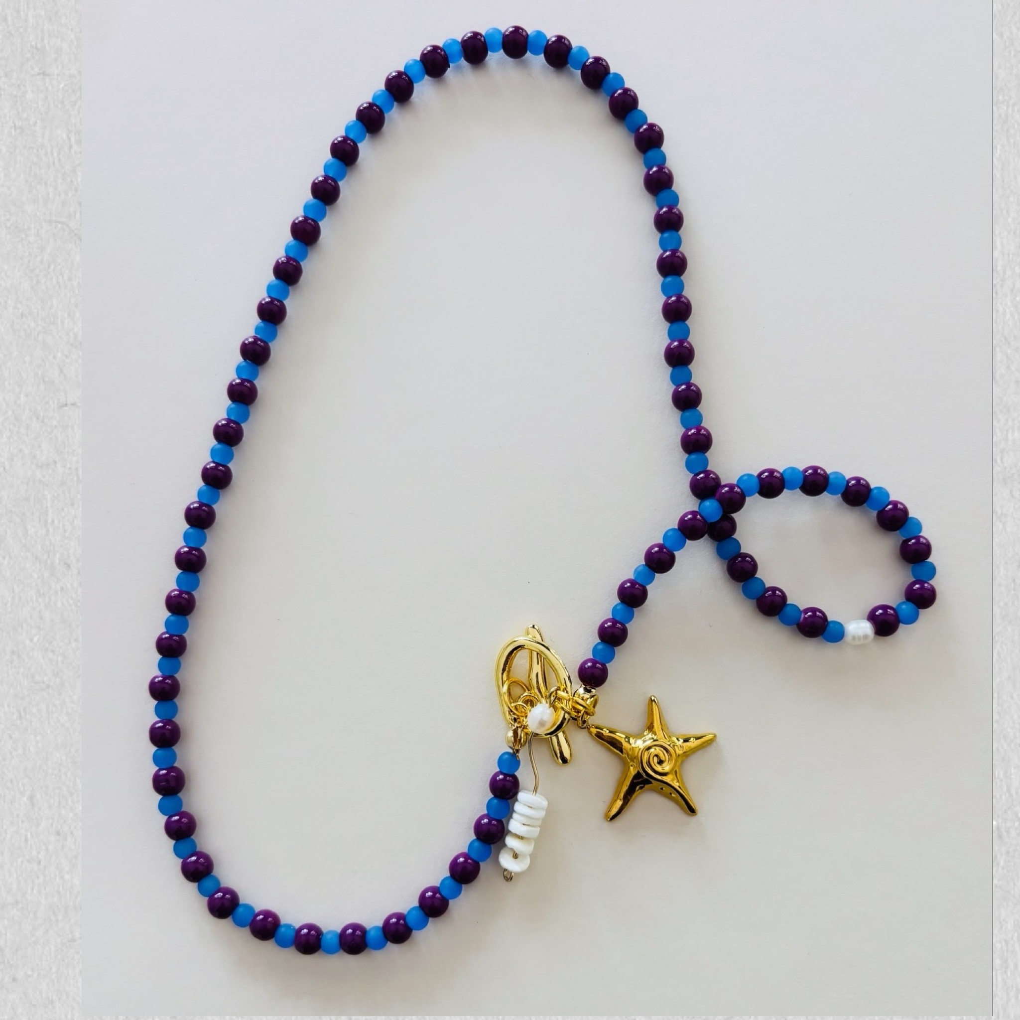 Beaded necklace with gold starfish charms