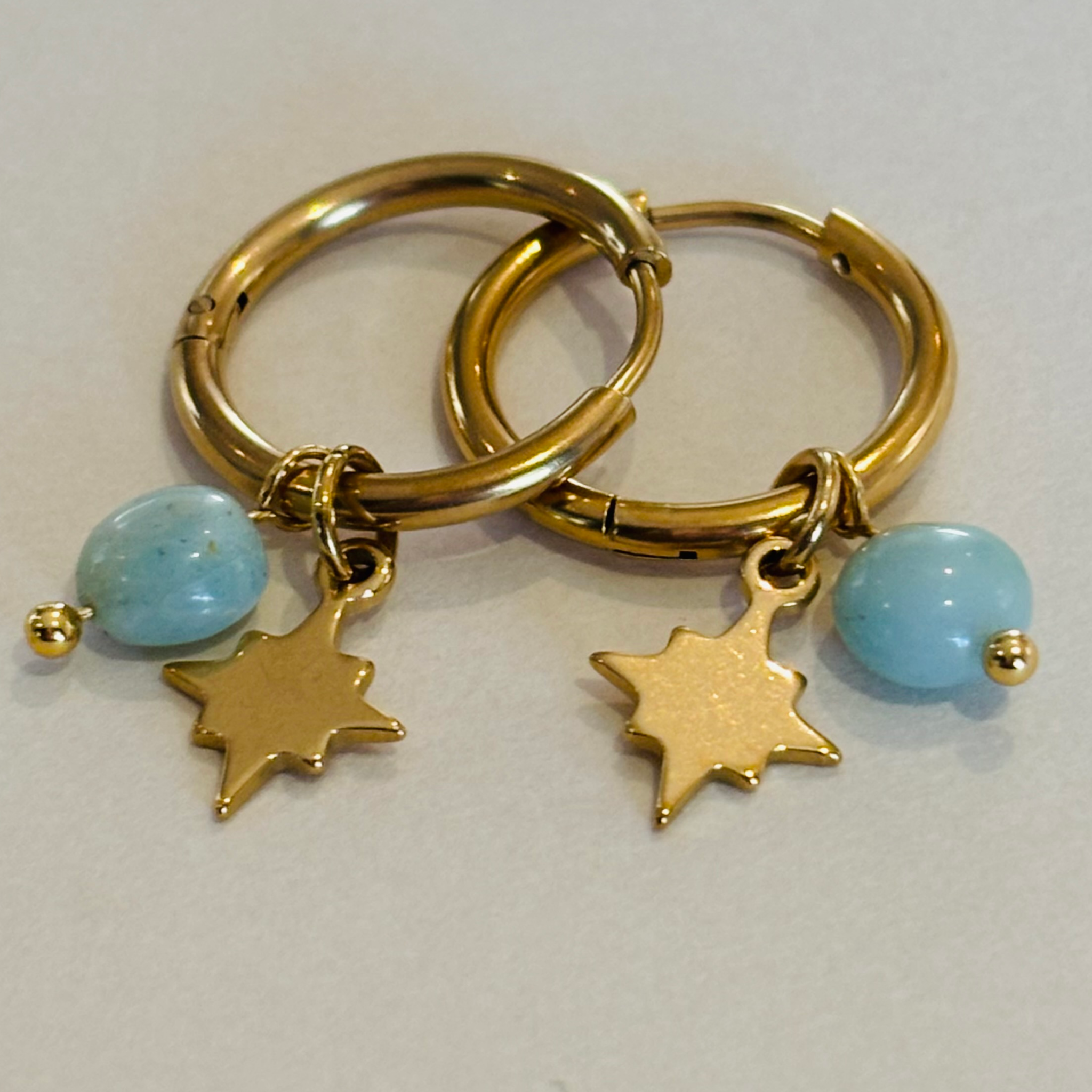 Gold hoop earrings with star and blue bead charms