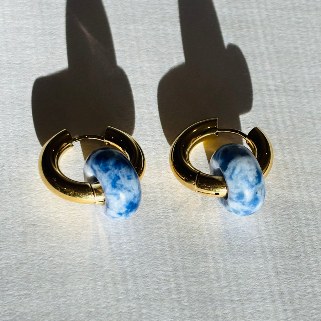 Pair of earrings with gold loops and blue stone