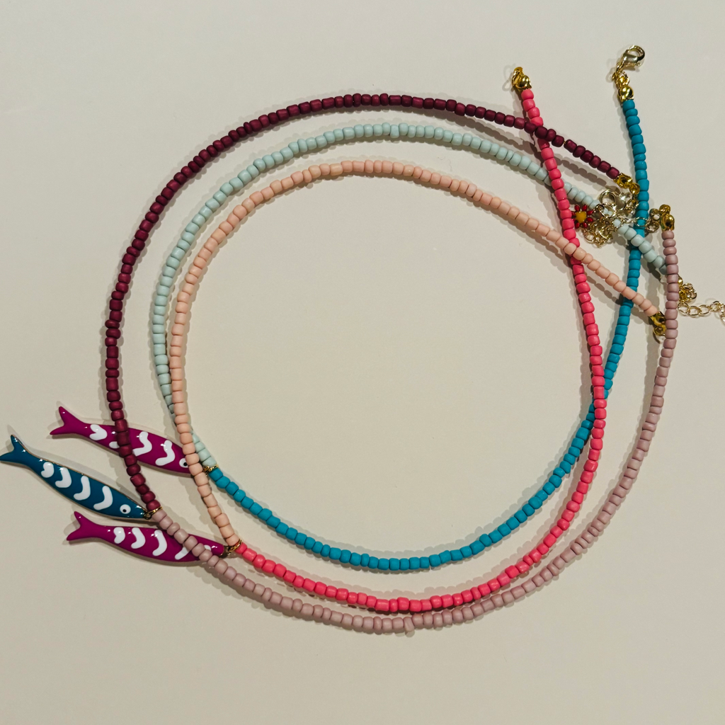 Set of colorful beaded bracelets with fish charms