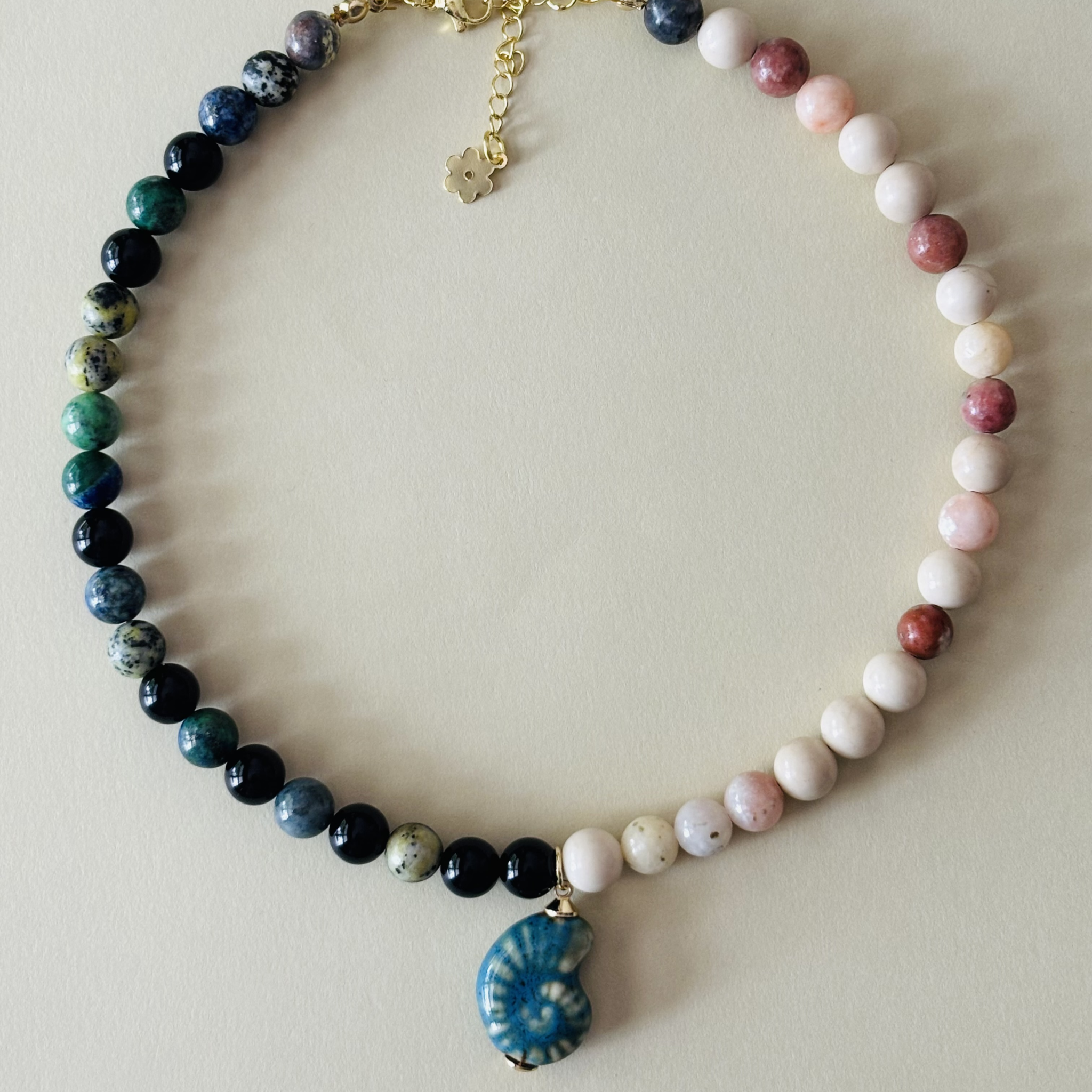 Handcrafted necklace with multicolored beads and a blue pendant 