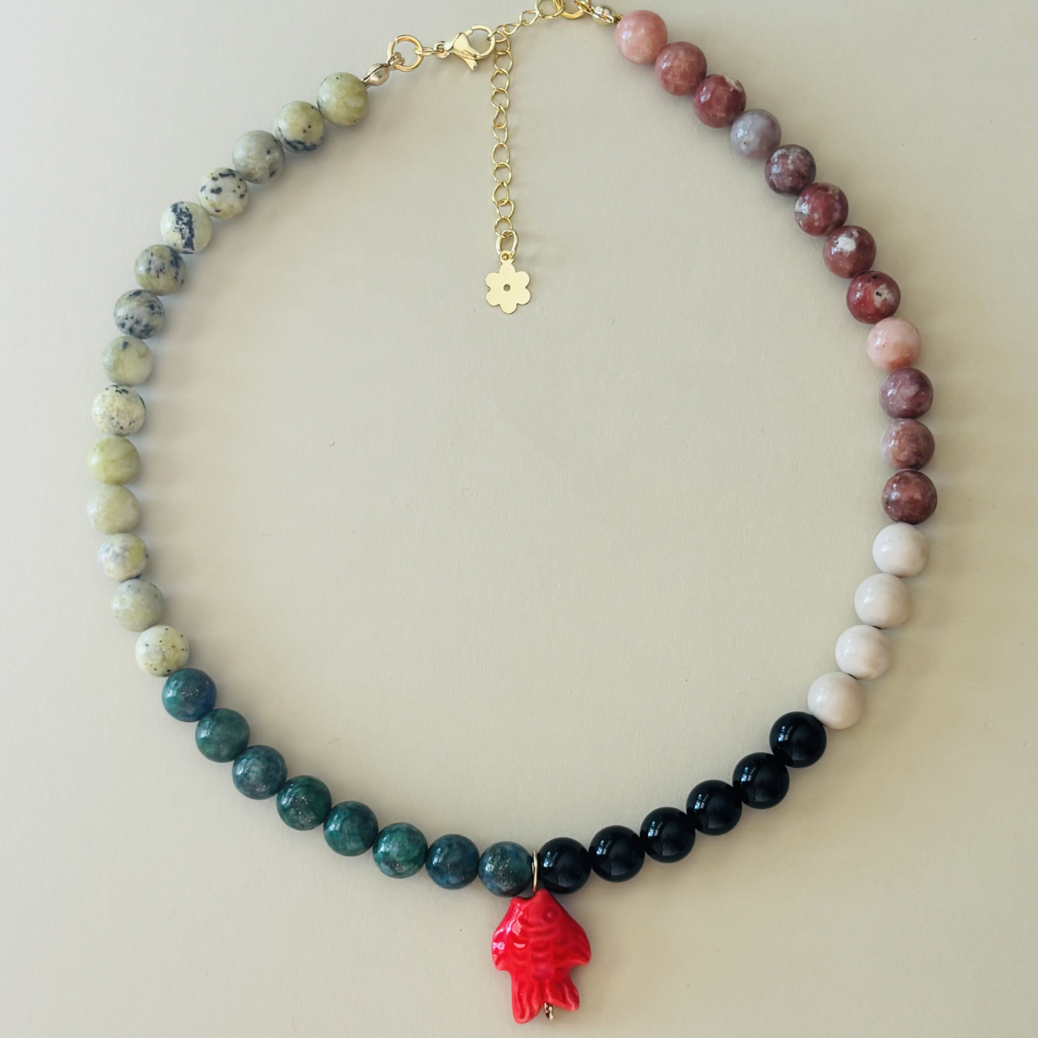 Handcrafted necklace with multicolored beads and a red charm