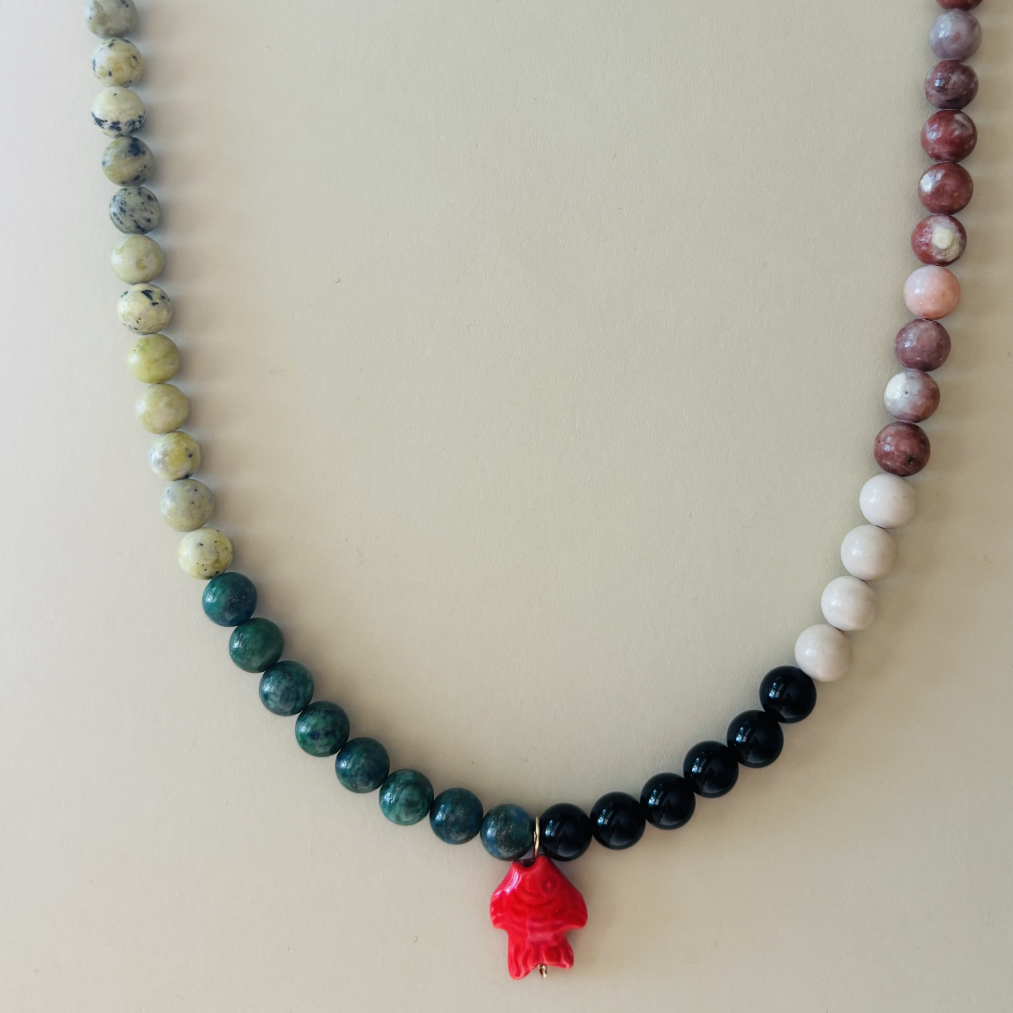 Handcrafted necklace with multicolored beads and a red pendant 