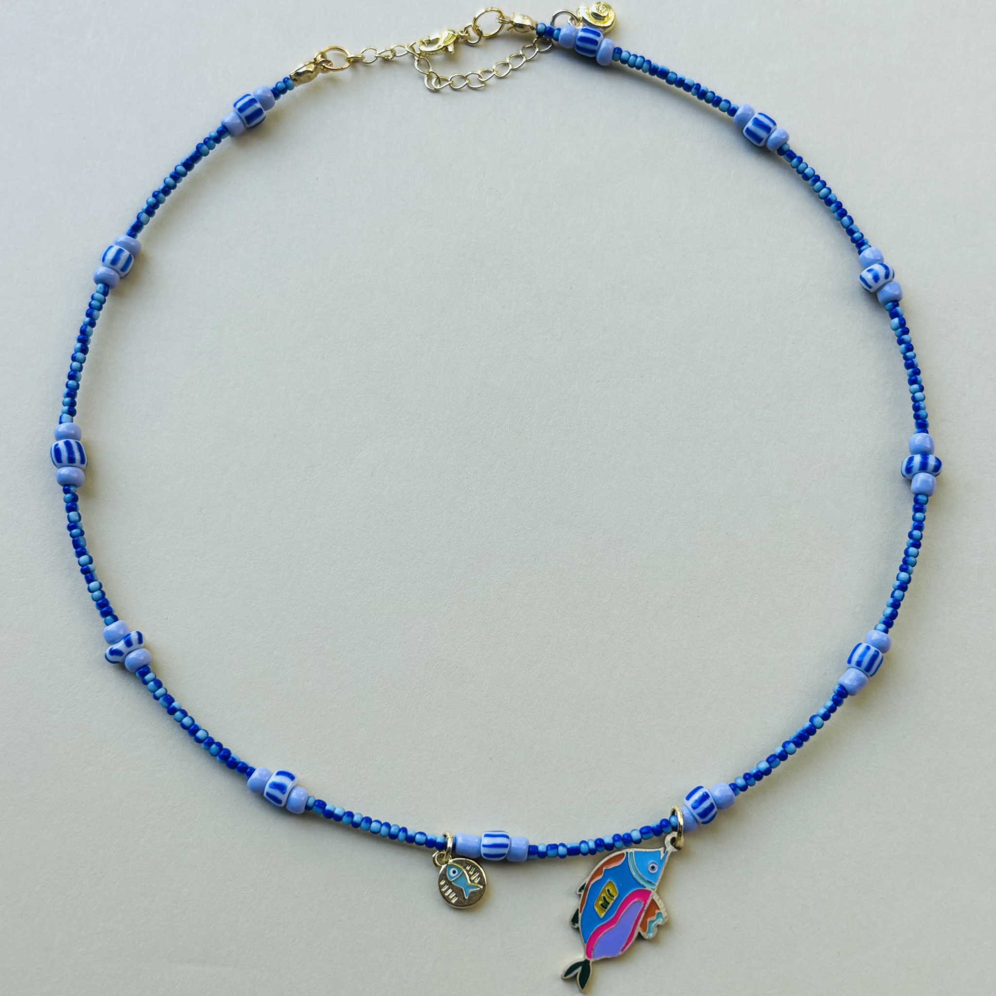 Blue handcrafted beaded necklace with a fish charm