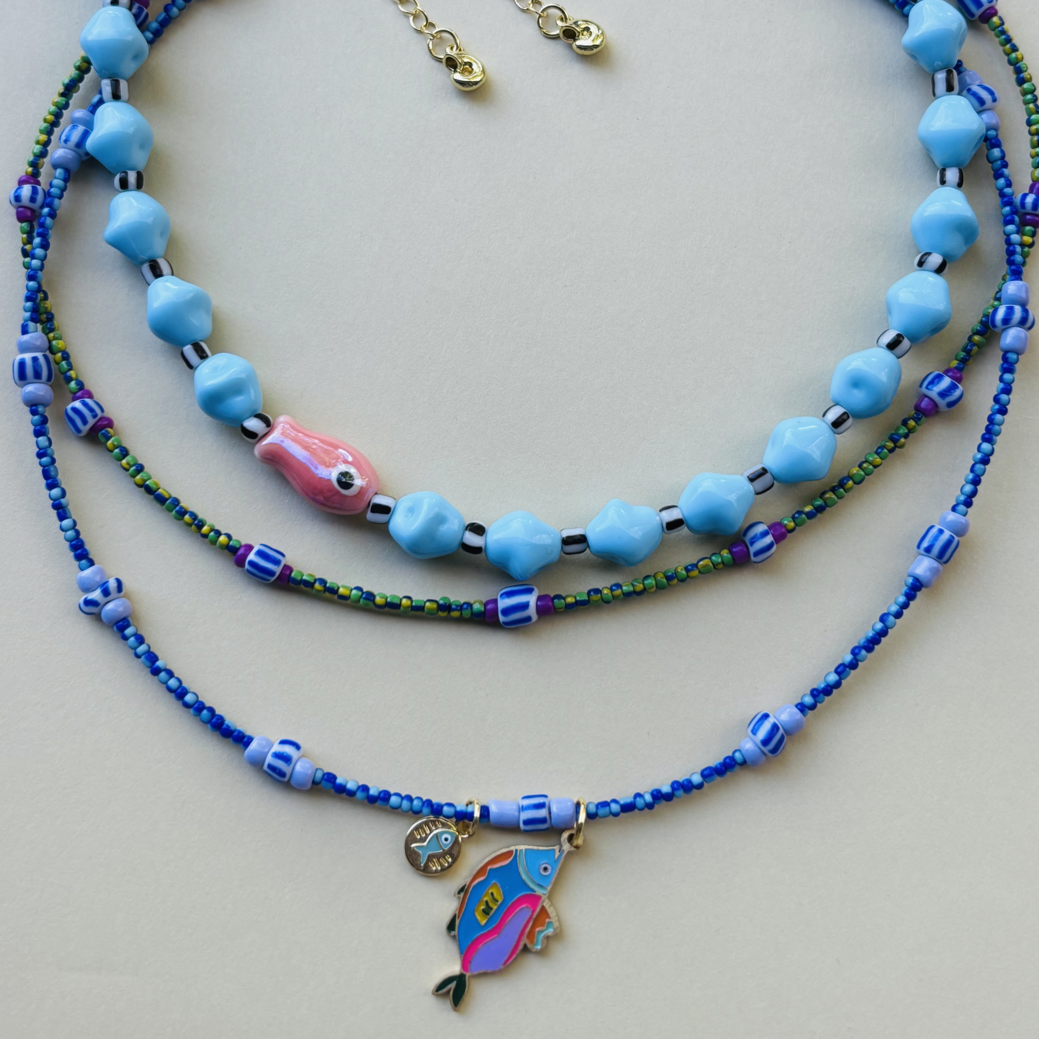 Handcrafted necklace with blue beads and fish charms