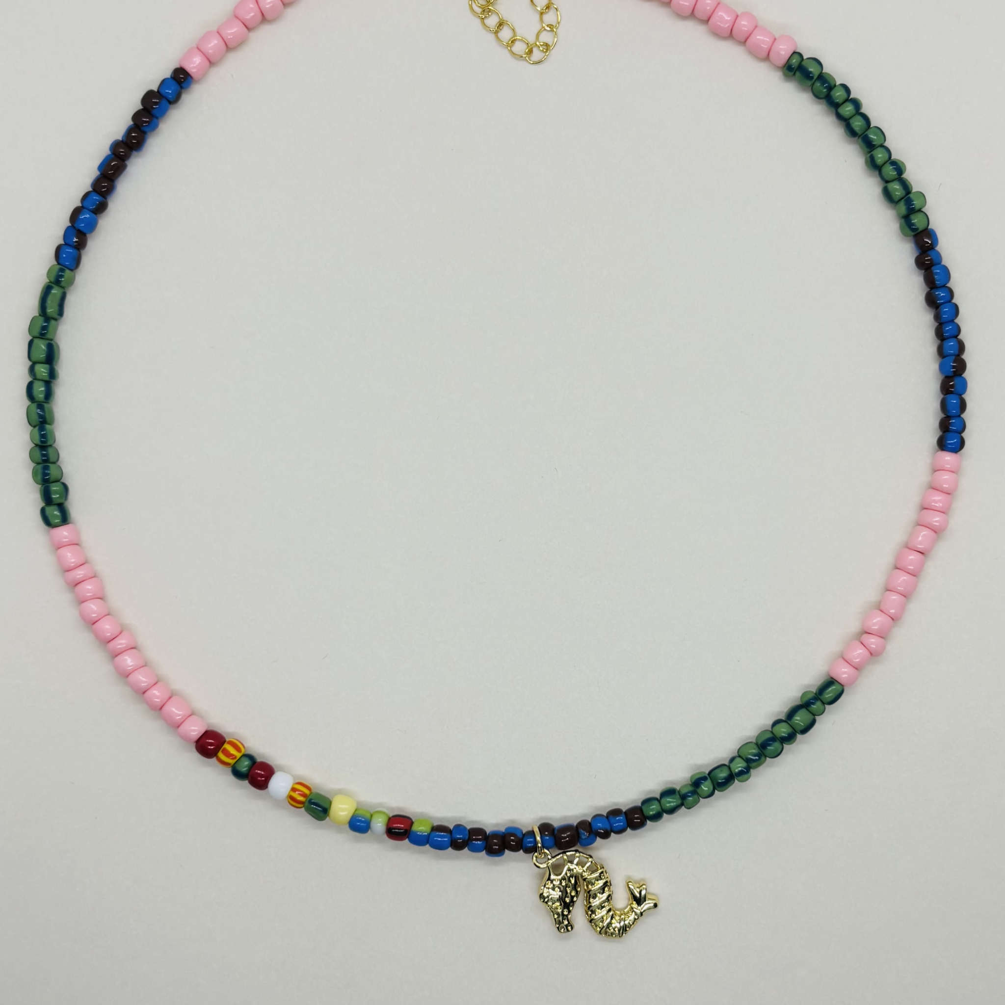 Handcrafted necklace with multicolored beads and a small charm