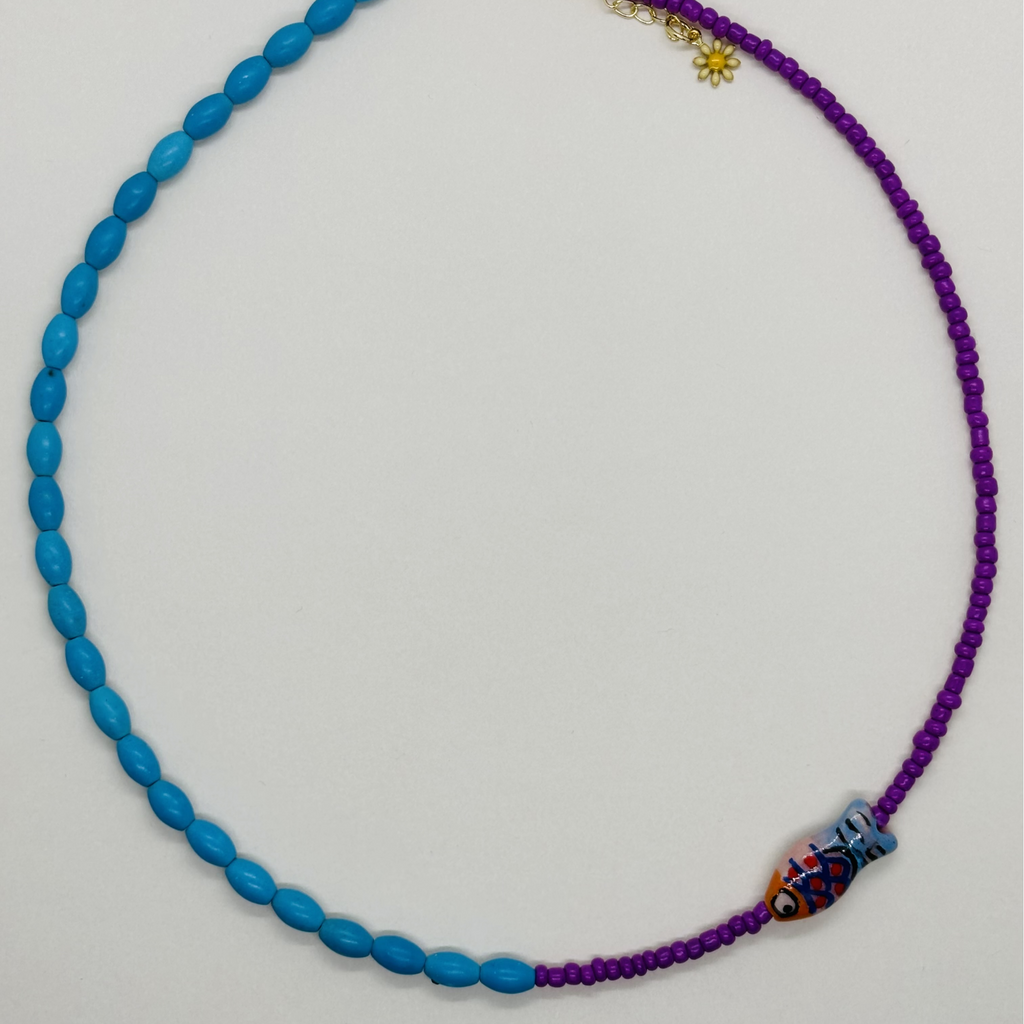 Necklace with blue and purple beads on a light gray background