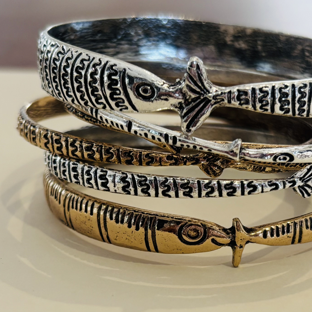 Stack of fish-shaped bracelets in bronze and silver