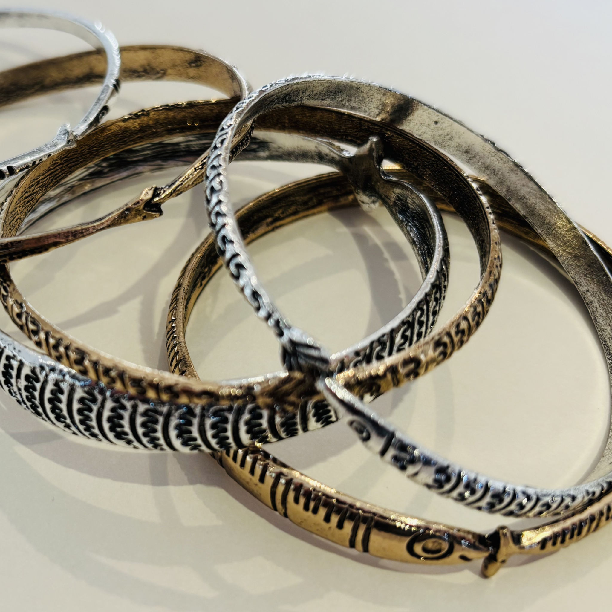 Set of metallic bracelets with intricate designs 