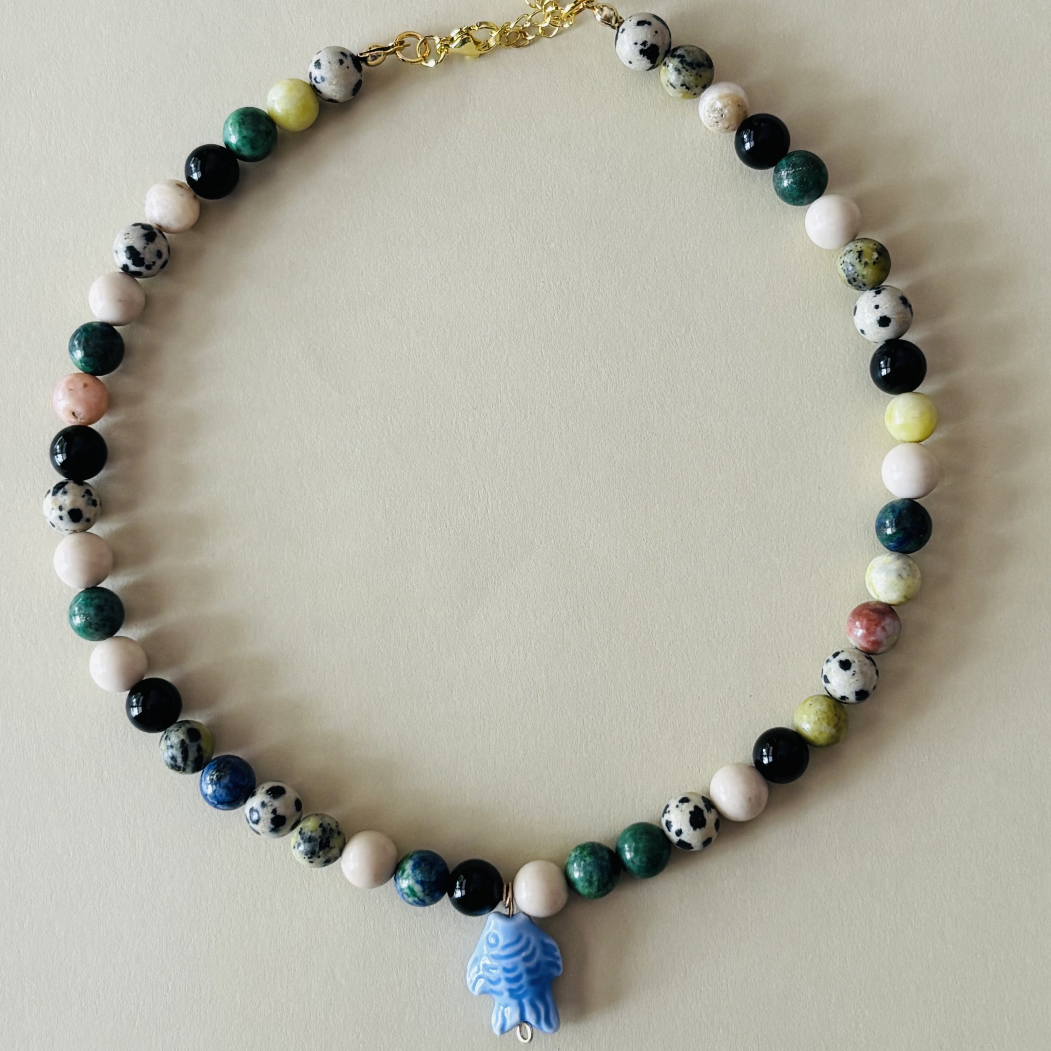 Handcrafted necklace with multicolored beads and a blue fish charm