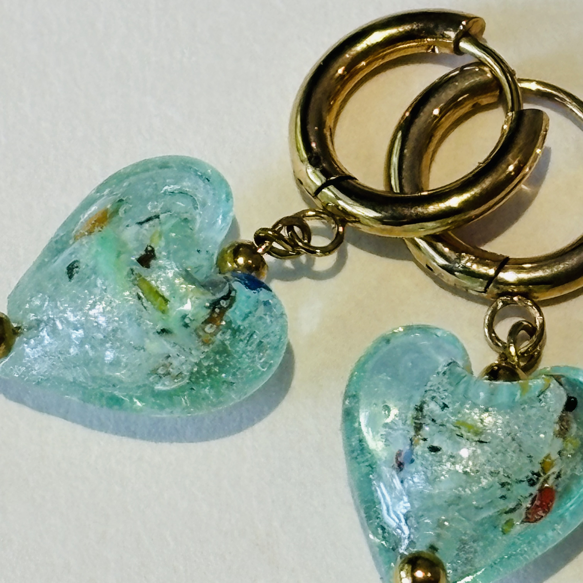 Gold hoop earrings with heart-shaped turquoise charms